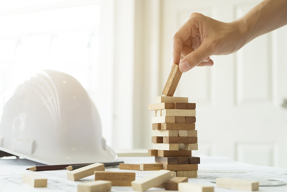 Hard hat with builder playing Jenga