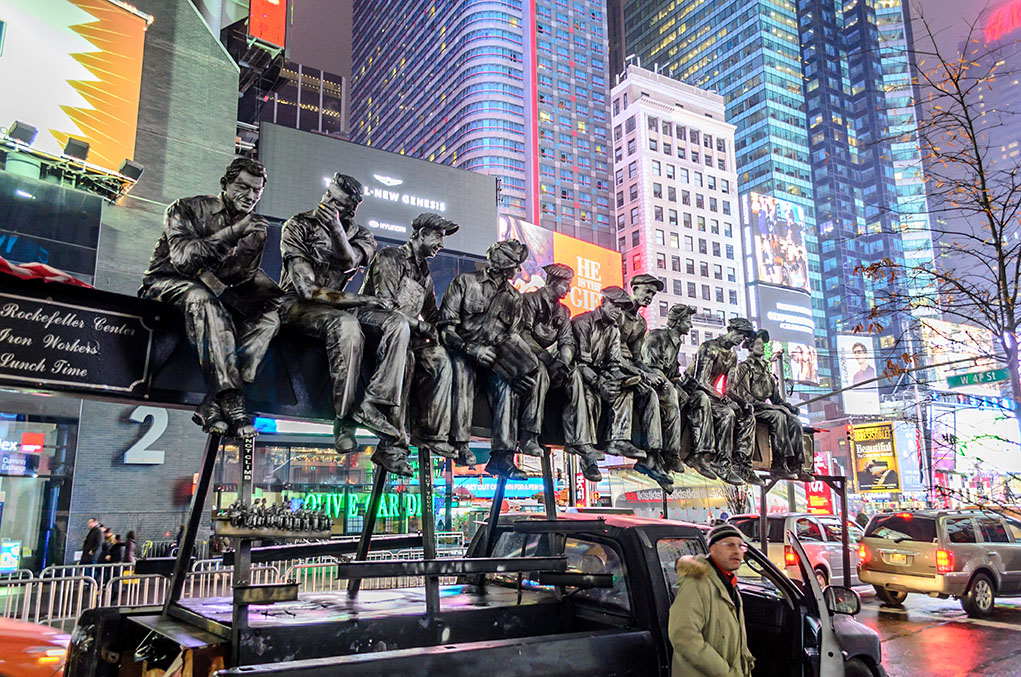 Statue representation of famous image showing workers eating lunch on a girder high above New York