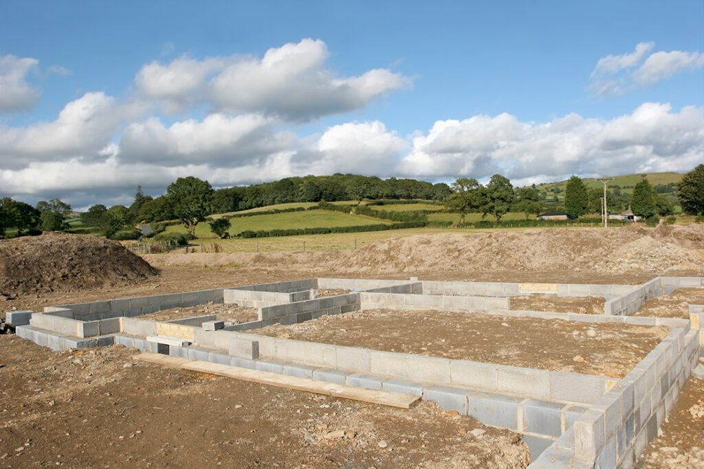 Building site with foundations and first layer of breeze blocks in place