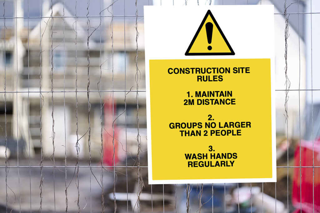 Notice on a building site fence giving Covid precaution instructions