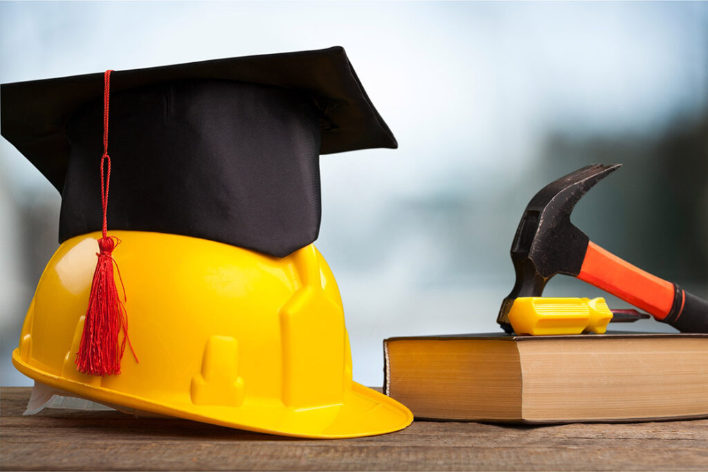Hard hat with mortor board on it, showing the importance of training and education in construction
