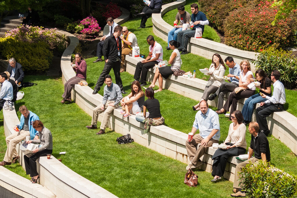 A green outdoor space where office workers can  gather to meet and enjoy lunch