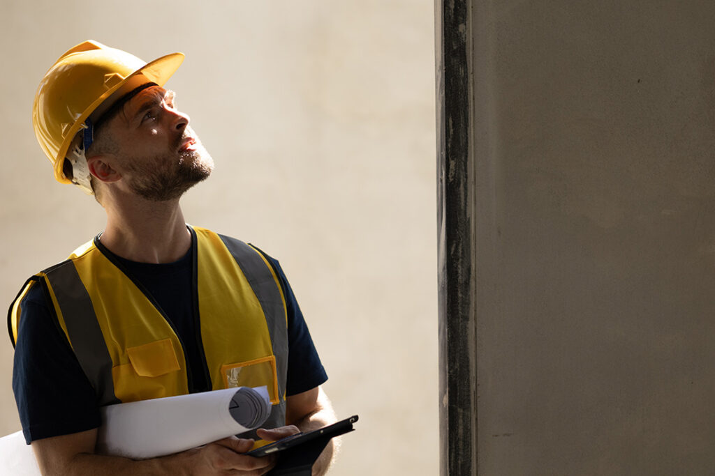 Builder in hard hat inspecting work